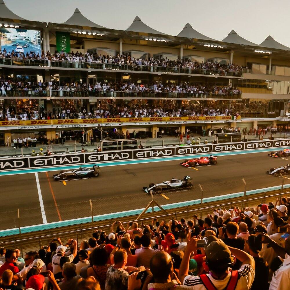 cars going past cheering spectators at the abu dhabi grand prix